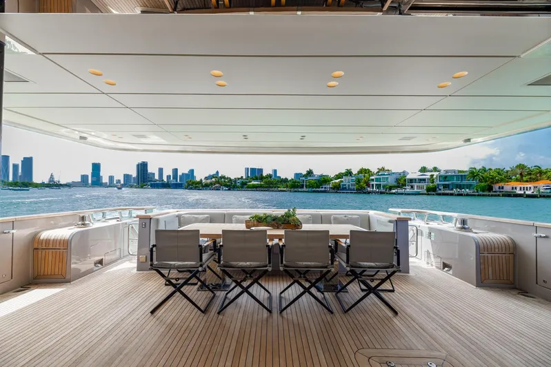 Legacy Yacht Photos Pics Luxurious Sanlorenzo SD96 yacht deck with seating, overlooking waterfront cityscape, 2022 model.