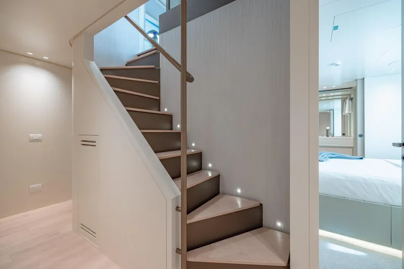Legacy Yacht Photos Pics Modern interior of 2022 Sanlorenzo SD96 yacht featuring elegant staircase and bedroom.