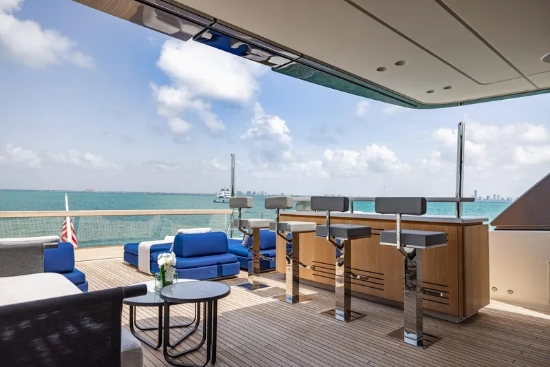 Legacy Yacht Photos Pics Luxurious 2022 Sanlorenzo SD96 yacht deck with bar, seating, and ocean view.