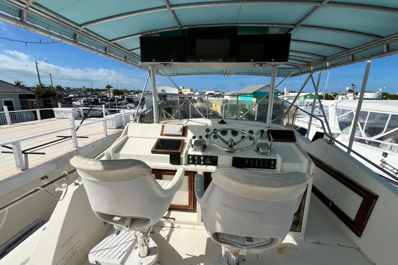  Yacht Photos Pics 1978 Hatteras 53 Yacht Fisherman helm with dual seats and navigation controls under a canopy.