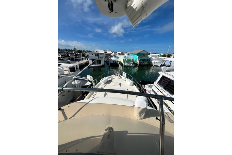  Yacht Photos Pics 1978 Hatteras 53 Yacht Fisherman docked in a marina under a clear blue sky.