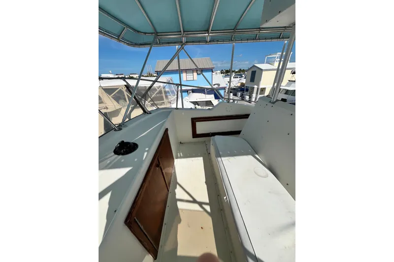  Yacht Photos Pics 1978 Hatteras 53 Yacht Fisherman interior with seating and storage under a blue canopy.