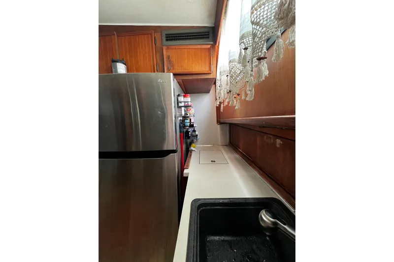  Yacht Photos Pics 1978 Hatteras 53 Yacht Fisherman kitchen with stainless steel fridge and wooden cabinets.