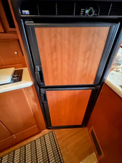  Yacht Photos Pics 2005 Silverton 35 Motor Yacht kitchen with wood-paneled refrigerator and countertop.