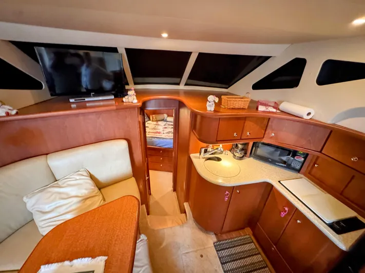  Yacht Photos Pics Interior of 2005 Silverton 35 Motor Yacht with cozy seating and compact kitchen area.