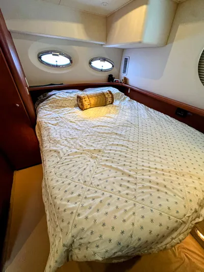  Yacht Photos Pics Cozy bedroom in 2005 Silverton 35 Motor Yacht with porthole windows and patterned bedding.