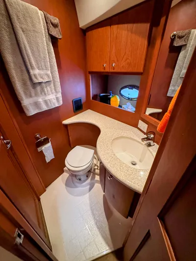  Yacht Photos Pics 2005 Silverton 35 Motor Yacht bathroom with sink, toilet, and wooden cabinetry.