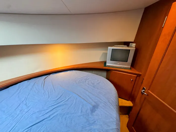  Yacht Photos Pics 2005 Silverton 35 Motor Yacht cabin with bed, TV, and wooden cabinetry.