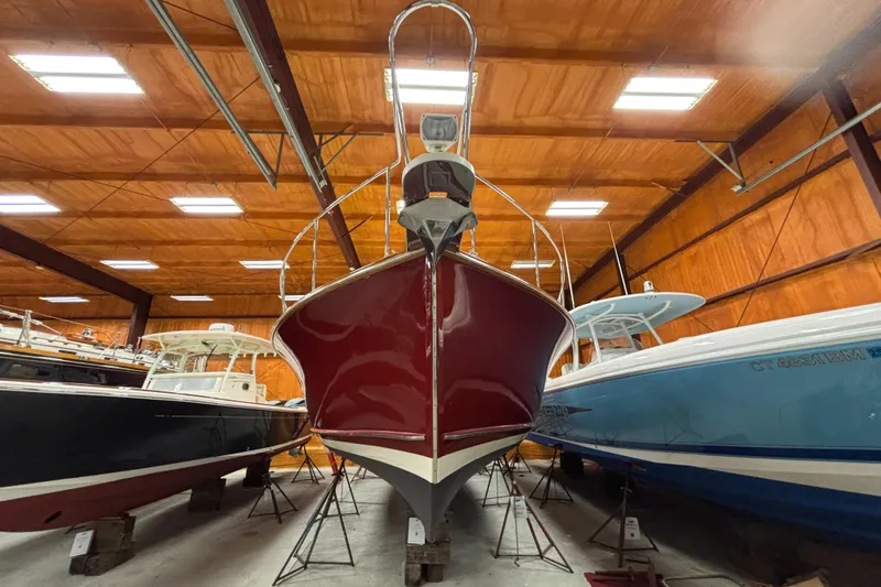 Lucy Yacht Photos Pics 2006 Ellis Express boat in storage, surrounded by other boats in a wooden warehouse.