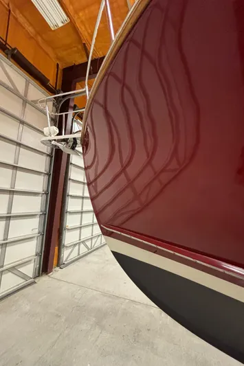 Lucy Yacht Photos Pics 2006 Ellis Express boat in a garage, showcasing sleek maroon hull design.