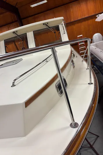 Lucy Yacht Photos Pics 2006 Ellis Express boat with sleek white deck and polished railings in a wooden interior.