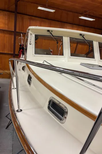Lucy Yacht Photos Pics 2006 Ellis Express boat in indoor storage, showcasing sleek design and polished metal railings.