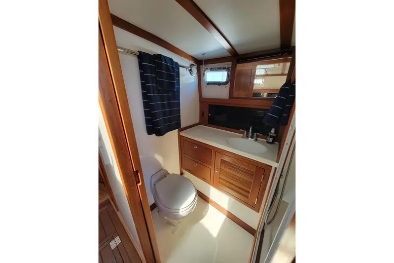 Lucy Yacht Photos Pics Bathroom interior of 2006 Ellis Express boat with wooden cabinetry and nautical decor.