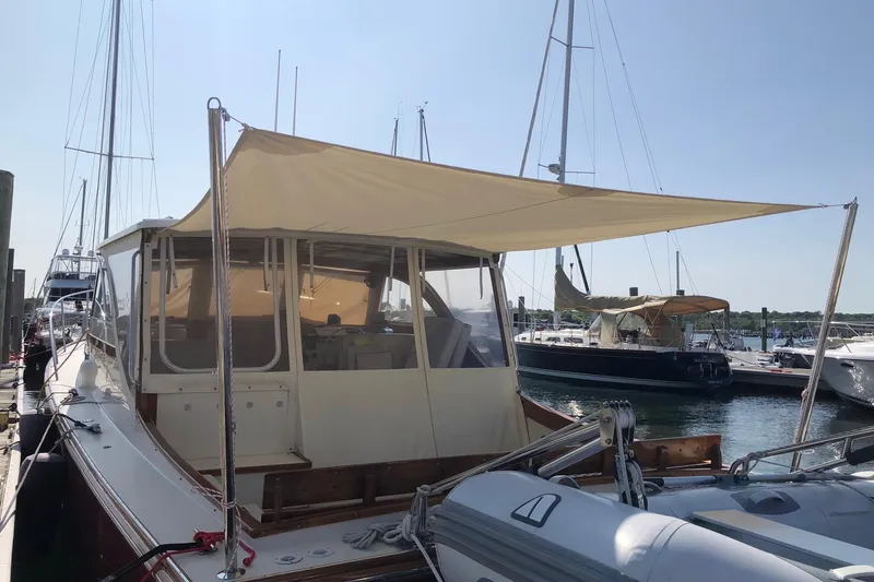 Lucy Yacht Photos Pics 2006 Ellis Express boat docked with sunshade, surrounded by other boats in a marina.
