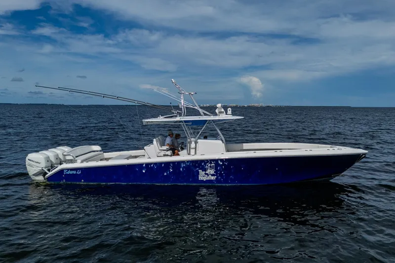 The Hogfather Yacht Photos Pics 2015 Bahama 41 boat on open water, blue hull, triple outboard engines.