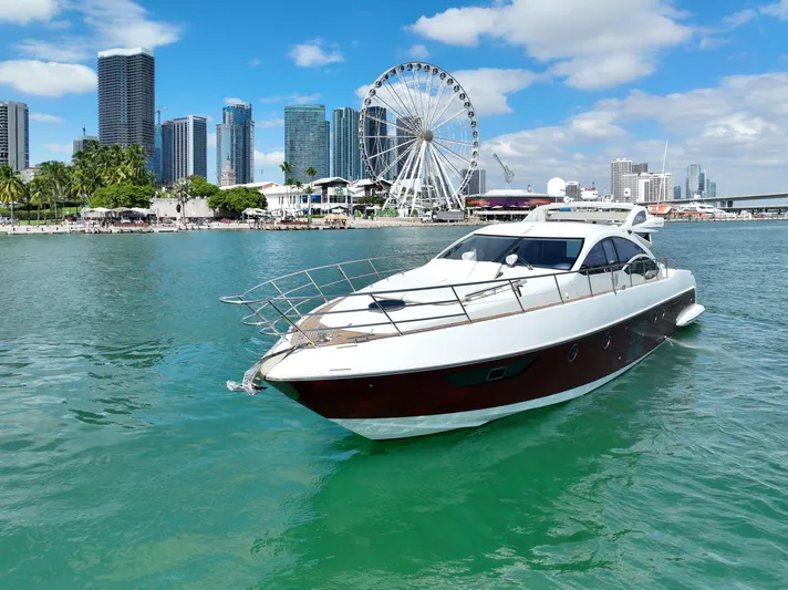 Warren Kelly Yacht Photos Pics Azimut 62S 2010 yacht cruising in urban waterfront with Ferris wheel and skyscrapers.