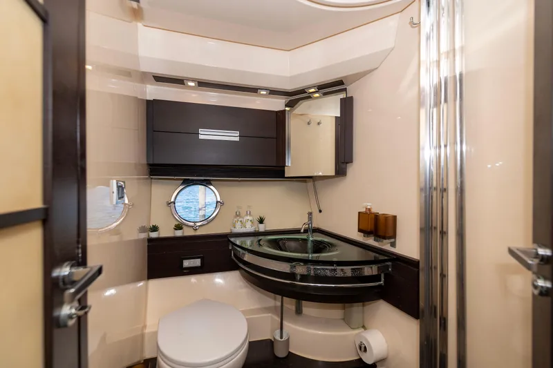 Warren Kelly Yacht Photos Pics Luxurious bathroom interior of 2010 Azimut 62S yacht with modern fixtures and porthole window.