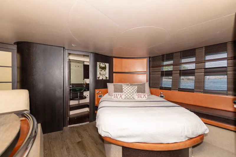 Warren Kelly Yacht Photos Pics Luxurious bedroom interior of 2010 Azimut 62S yacht with modern design and cozy ambiance.