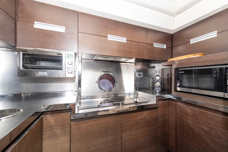 Warren Kelly Yacht Photos Pics Luxurious kitchen interior of 2010 Azimut 62S yacht with modern appliances and wood cabinetry.