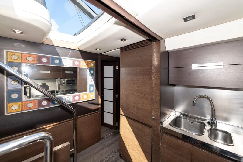 Warren Kelly Yacht Photos Pics Luxurious interior of 2010 Azimut 62S yacht with modern kitchen and decorative mirror.