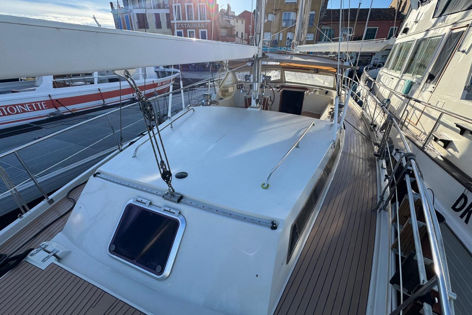 Amel Super Maramu 2000 sailboat, 2002 model, docked in a marina with surrounding boats.