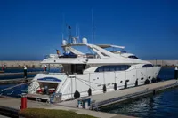 Luxury yacht Custom Line 112, 2005 model, docked in a marina under clear blue skies.