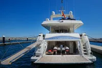 Luxury yacht Custom Line 112, 2005 model, docked with open garage and jet skis.