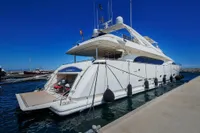 Luxury yacht Custom Line 112, 2005 model, docked at marina under clear blue sky.