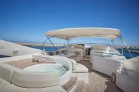 Luxurious 2005 Custom Line 112 yacht deck with jacuzzi and seating under canopy.