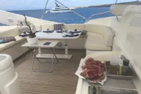 Luxurious yacht deck with dining setup, steaks, and ocean view; Custom Line 112, 2005 model.
