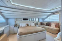 Luxurious bedroom interior on a 2005 Custom Line 112 yacht, featuring elegant design and cozy seating.