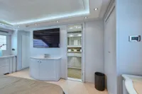 Luxurious yacht interior with modern decor, featuring a wall-mounted TV and sleek cabinetry.