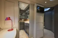 Luxurious yacht interior with modern bathroom, red lamp, and TV. Custom Line 112, 2005 model.