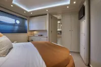 Luxurious yacht bedroom with modern design, featuring cozy bedding and ambient lighting, Custom Line 112, 2005.