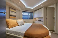 Luxurious bedroom interior on 2005 Custom Line 112 yacht, featuring modern decor and ambient lighting.
