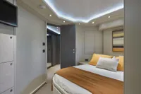 Luxurious bedroom interior on a 2005 Custom Line 112 yacht, featuring modern design and ambient lighting.
