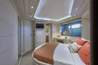 Luxurious yacht bedroom with modern decor, featuring a cozy bed and ambient lighting, Custom Line 112.