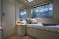 Luxurious yacht cabin interior with bed, pillows, and porthole windows, Custom Line 112, 2005.