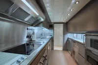 Modern stainless steel kitchen in a 2005 Custom Line 112 yacht.