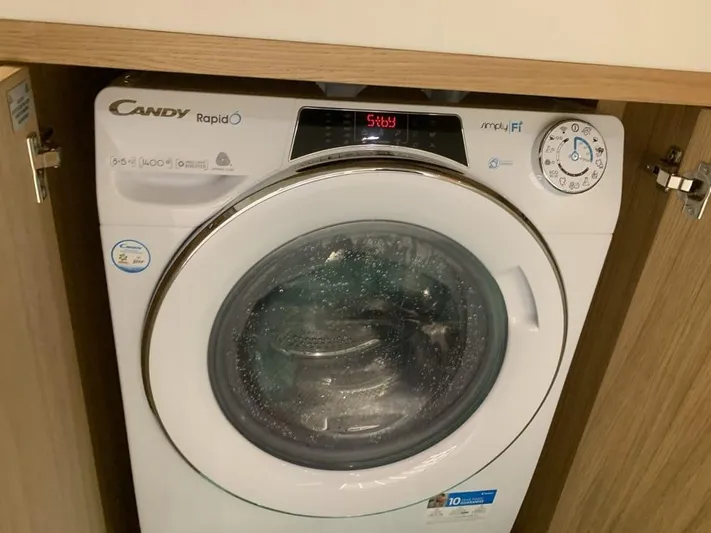  Yacht Photos Pics Front-loading Candy washing machine in a wooden cabinet.