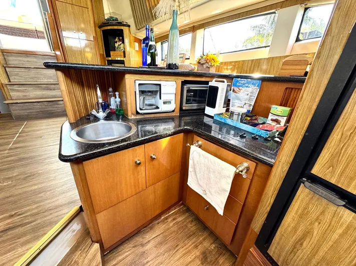 Craver Yacht Photos Pics 2001 Carver 396 Motor Yacht kitchen with sink, microwave, and wooden cabinetry.