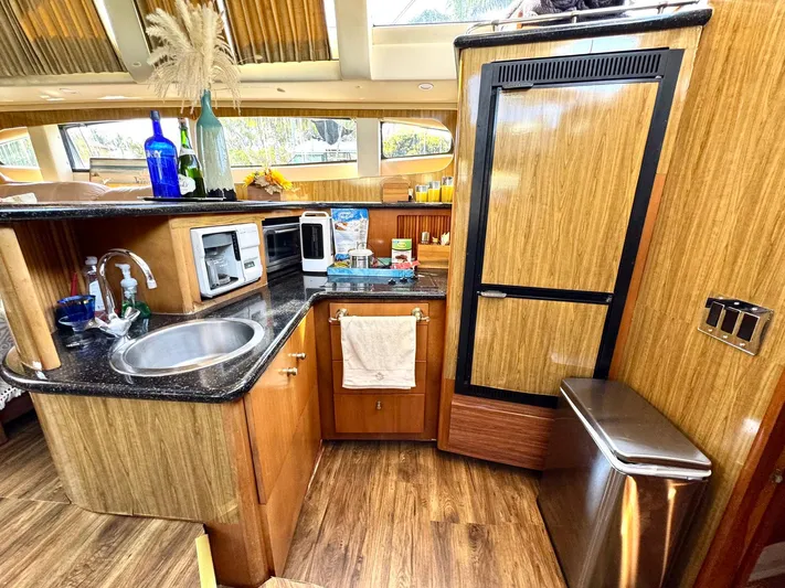 Craver Yacht Photos Pics 2001 Carver 396 Motor Yacht kitchen with wood cabinetry, sink, and appliances.