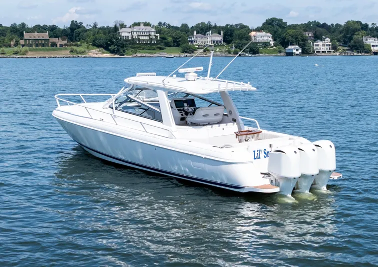 Lil' Sumpin II Yacht Photos Pics 2015 Intrepid 430 Sport Yacht on serene water with scenic shoreline background.