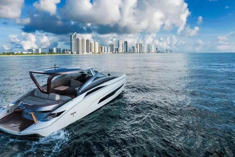 Lamborghini Tecnomar Yacht Photos Pics Luxurious Tecnomar 55 Evo yacht cruising near a city skyline under a vibrant sky.
