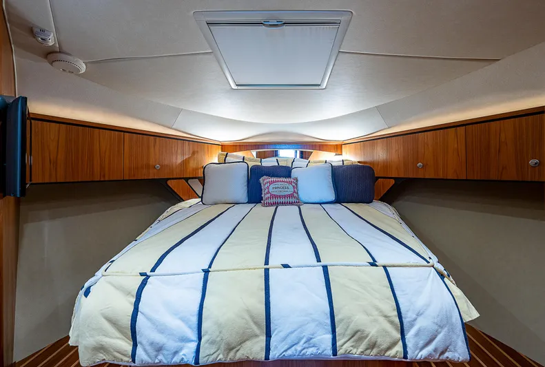 Second Chance II Yacht Photos Pics 2007 Tiara Yachts 4300 Sovran cabin with striped bedding and wooden cabinetry.