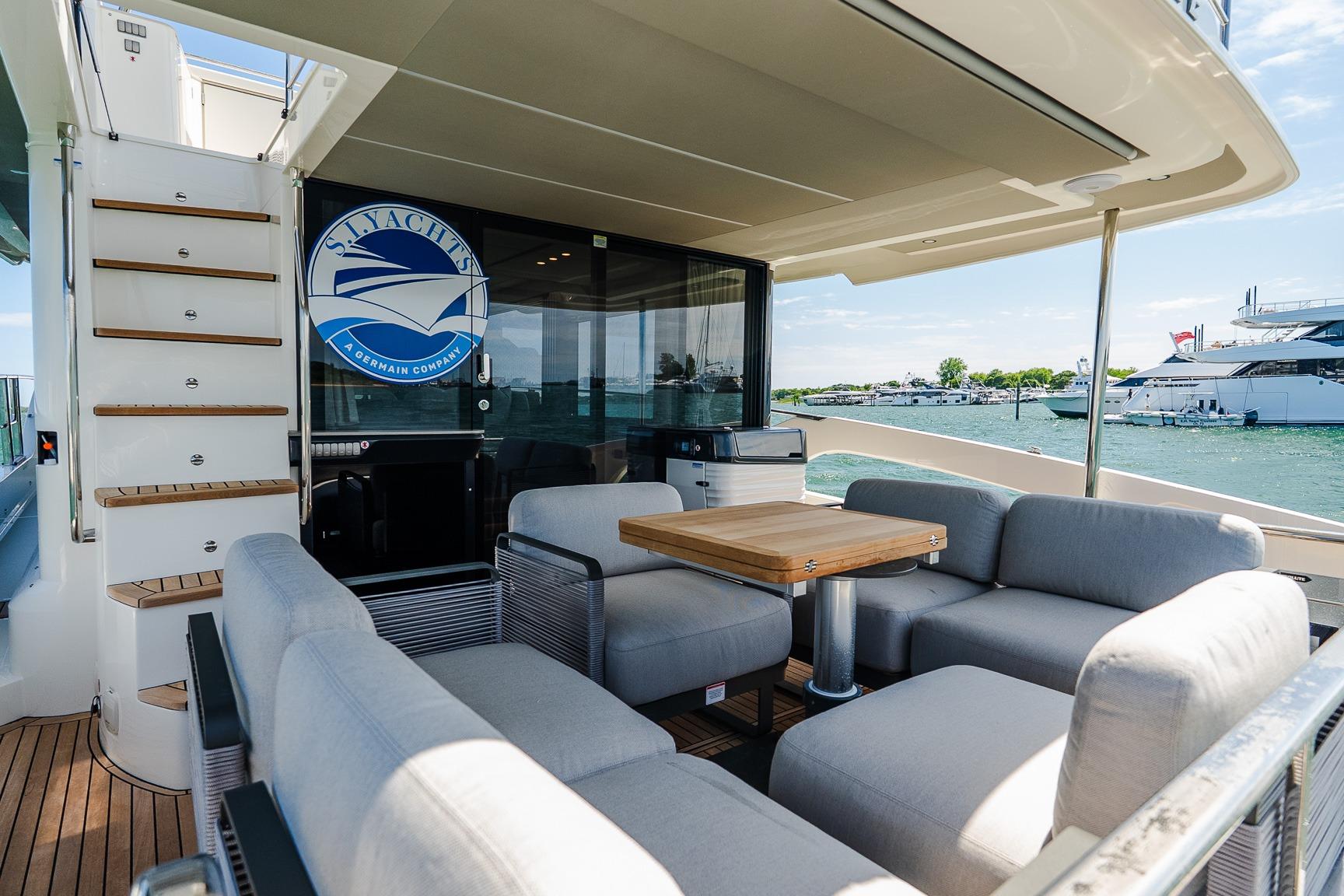 Luxurious 2026 Absolute Navetta 53 yacht deck with comfortable seating and scenic marina view.
