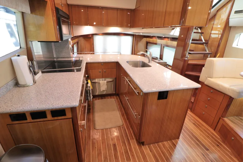  Yacht Photos Pics Luxurious kitchen interior of 2007 Hatteras 64 Motor Yacht with wood cabinetry and modern appliances.