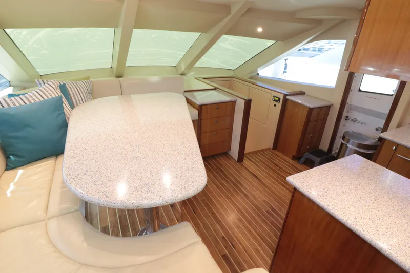  Yacht Photos Pics Luxurious interior of 2007 Hatteras 64 Motor Yacht with modern dining area and wood flooring.