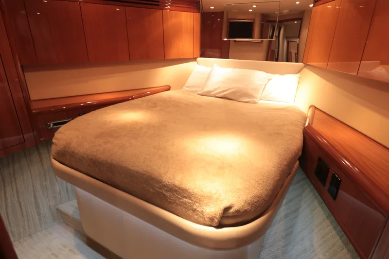  Yacht Photos Pics Luxurious bedroom interior of 2007 Hatteras 64 Motor Yacht with wood paneling.