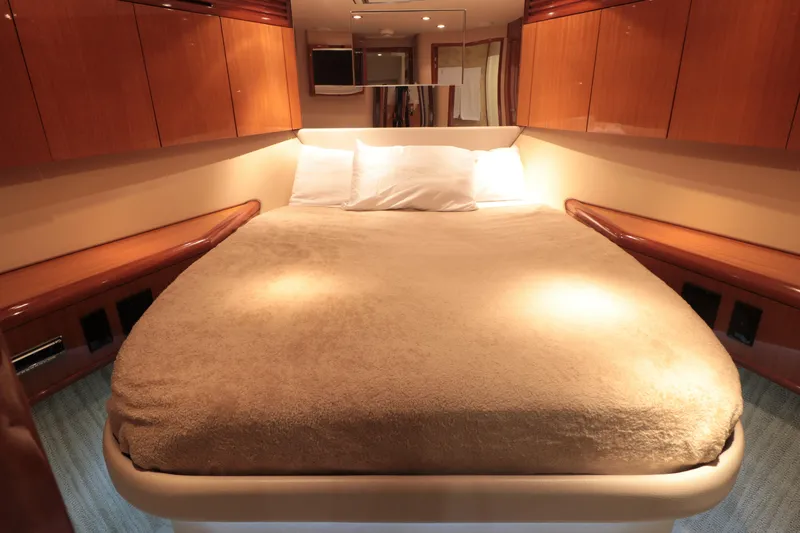  Yacht Photos Pics Luxurious bedroom interior of 2007 Hatteras 64 Motor Yacht with cozy lighting.